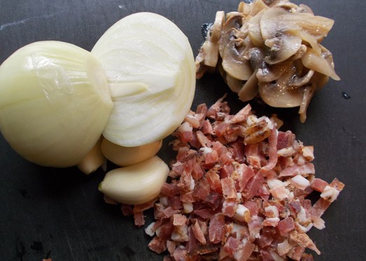 Zwiebel und Knoblauch fein hacken. Speck würfelig schneiden.