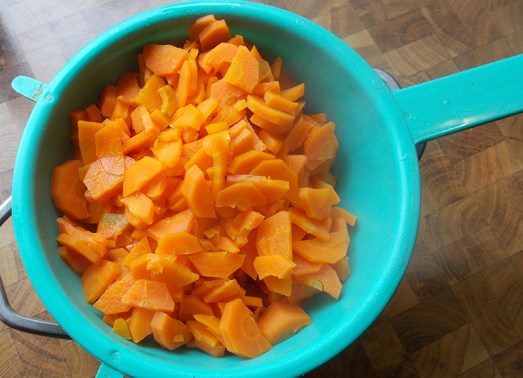 Karotten putzen, blättrig schneiden und in Salzwasser bissfest kochen, Wasser abgießen.
