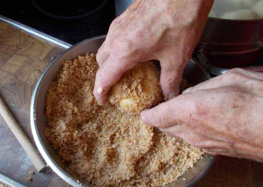 Die gekochten Knödel  in der Bröselmischung walzen. 