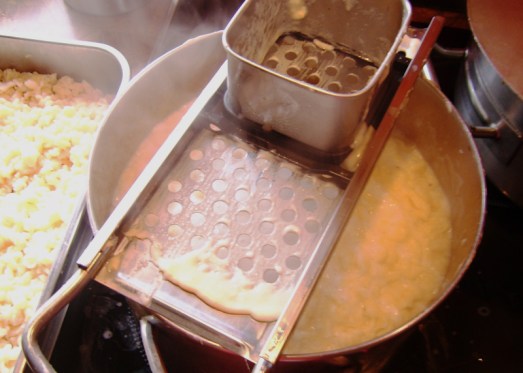 Danach die Masse mit Nockerlsieb oder Nockerlhobel direkt ins kochende Salzwasser streichen, aufkochen, im kalten Wasser abschrecken, auf ein Sieb geben und abtropfen lassen.