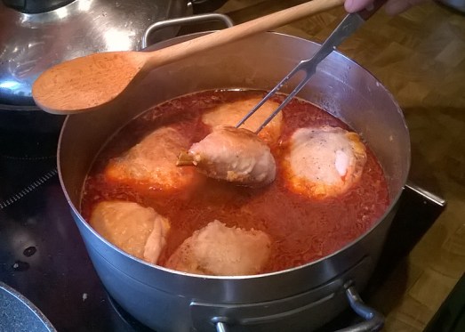 Die angebratenen Hühnerteile in die Paprikasauce legen und zugedeckt 15 Minuten köcheln lassen. 