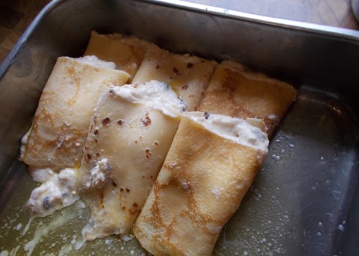 ... und in die mit flüssiger Butter vorbereitete Form schlichten, dabei durch die Butter ziehen (siehe Video!) Idealerweise steht die Form leicht schräg, damit sich die Butter an einem Ende sammelt.