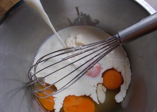 Wenn die Form gefüllt ist, Ei mit Milch und ein wenig Obers versprudeln ...