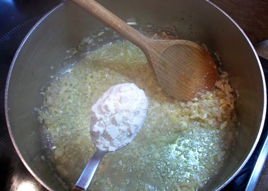 Für eine helle Einbrenn klein geschnittenen Zwiebel und Knoblauch in Butterschmalz leicht anrösten, mit Mehl stauben ...