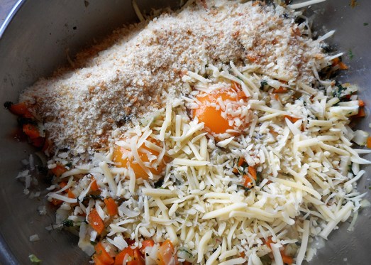 Den blanchierten Blattspinat durchhacken und noch etwas mit den Zwiebeln anrösten lassen, bevor man alles unter das blanchierte Gemüse mischt. Eier dazugeben (hier gezeigte Menge: zwei Eier), Semmelbrösel (hier: drei gut gehäufte EL), geriebenen Käse und das gehackte Petersiliengrün.